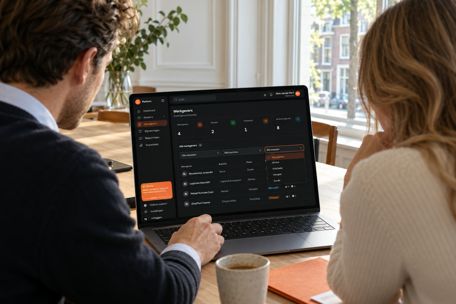 Twee collega's bekijken het DIM-dashboard op een laptop