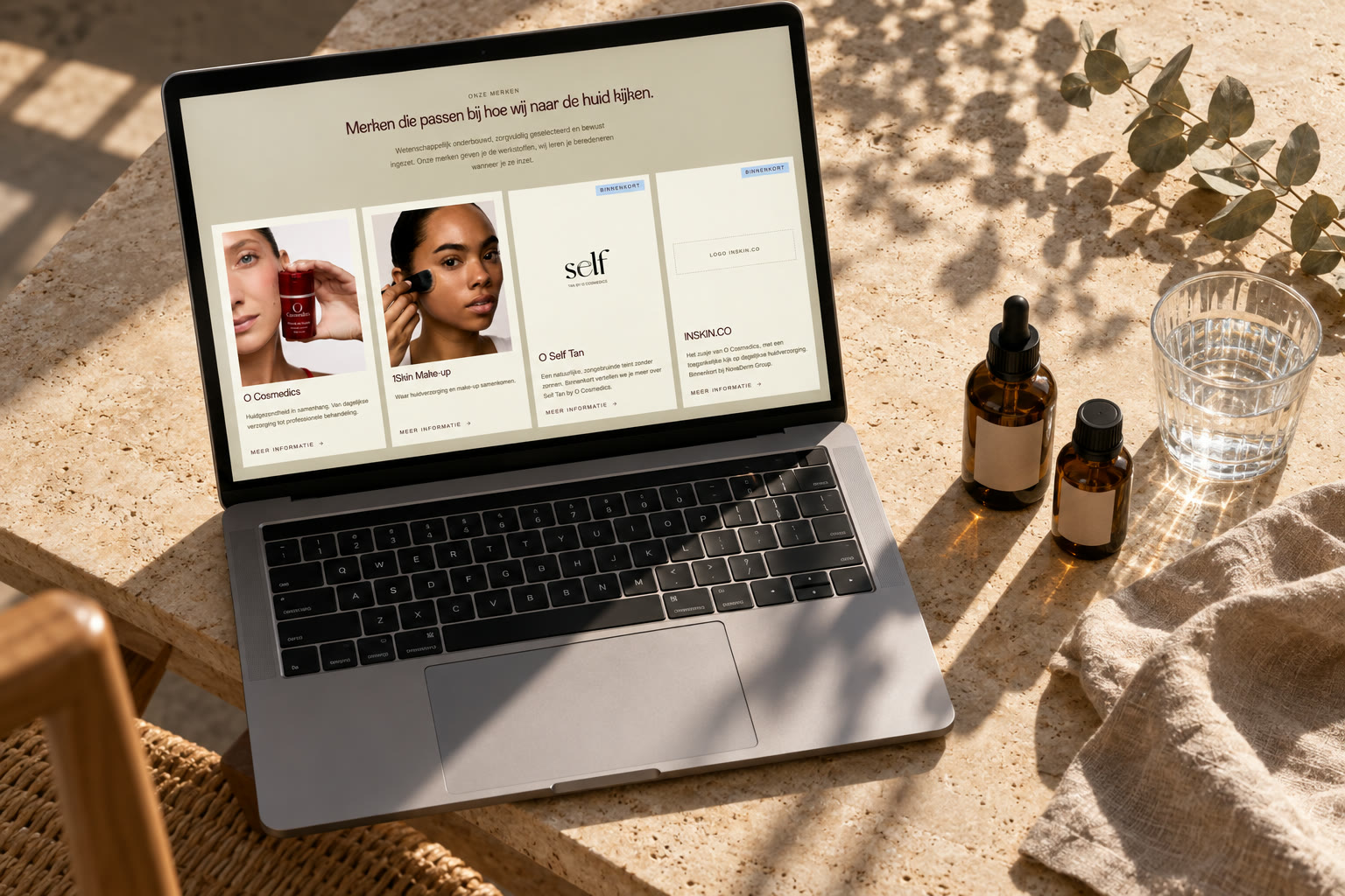 De NovaDerm Group website op een laptop tussen skincareproducten