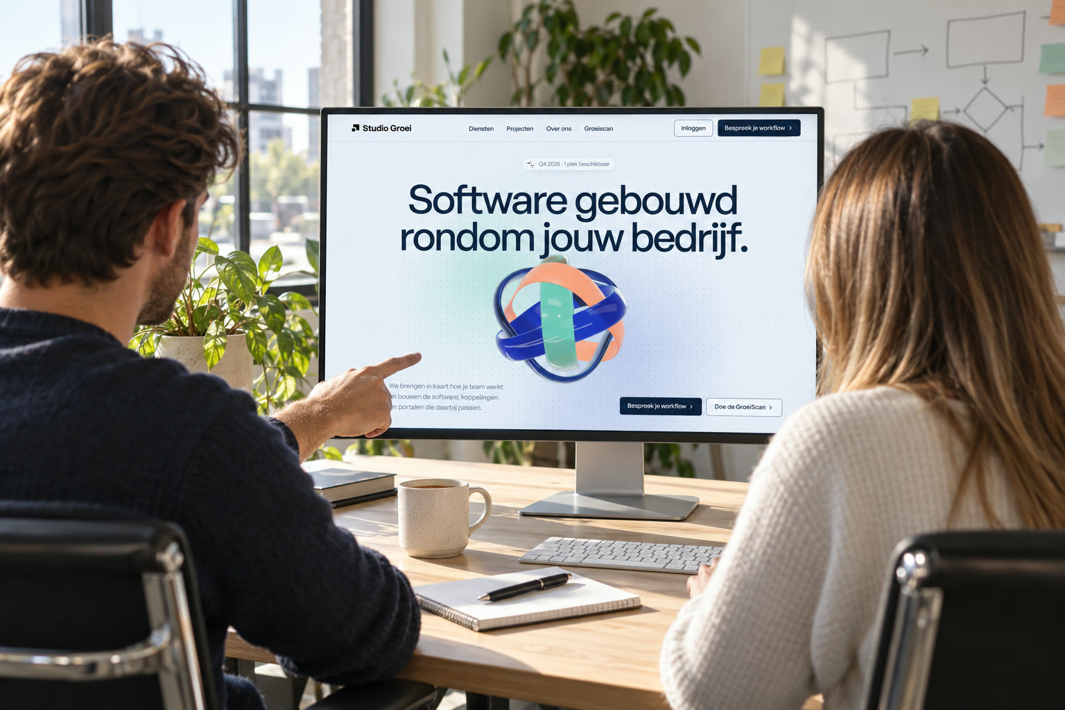 Twee mensen bespreken de Studio Groei website op een groot scherm